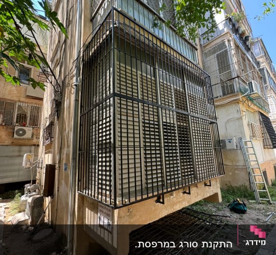 מרפסת עם סורגים מתכתיים וחלונות זכוכית
